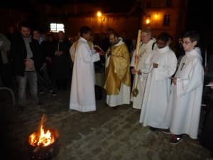 le père François-Xavier bénit le feu, assisté du père Michel Guyot et du diacre Patrick