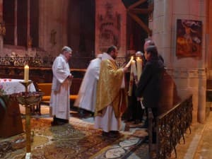 Le père François-Xavier allume les cierges pascals destinés aux paroisses de Brinon, Lormes et Tannay